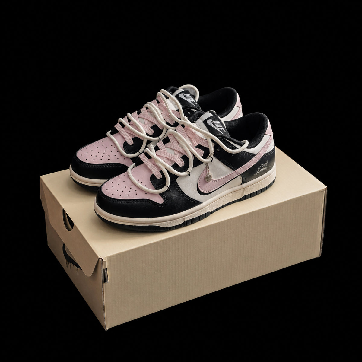 Dunk Low en negro, rosa y crema con doble cordonera